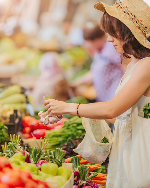 photo of a woman shopping for produce at a market