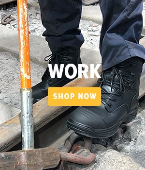 Person standing on a railtrack wearing work boots