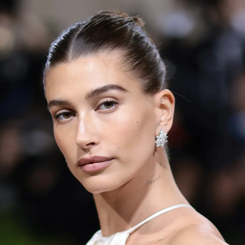 headshot of hailey bieber with slicked back updo 