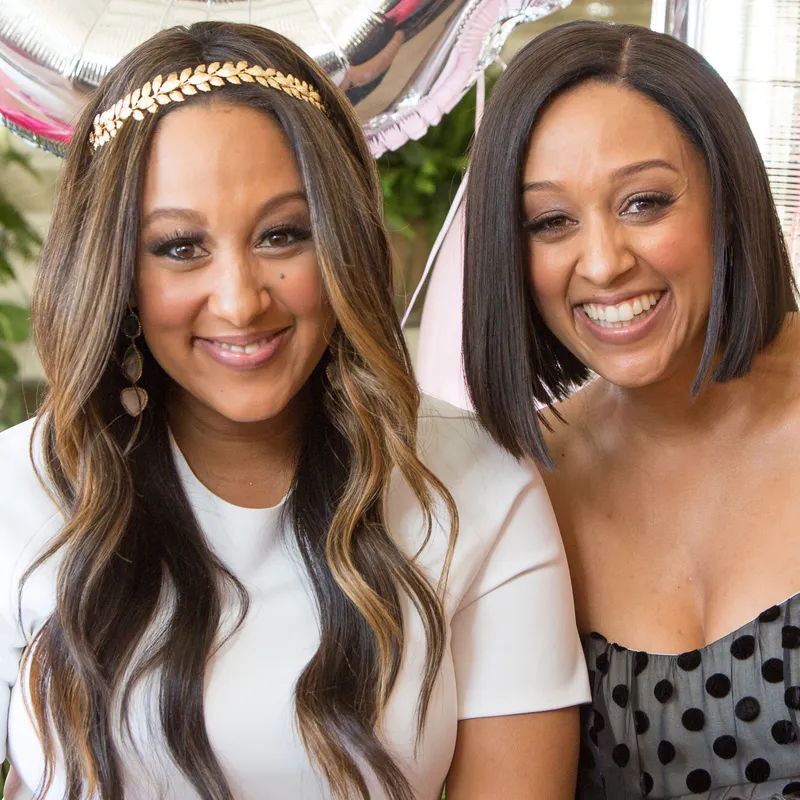 headshot of tia and tamera mowry with big wide smiles 