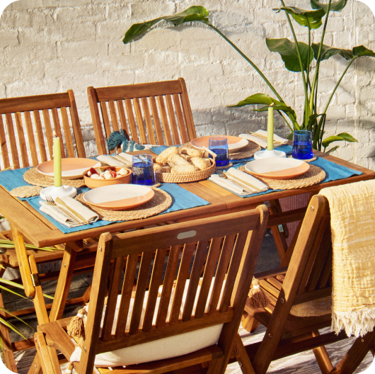 An outdoor dining table with place settings linking to european summer edit page