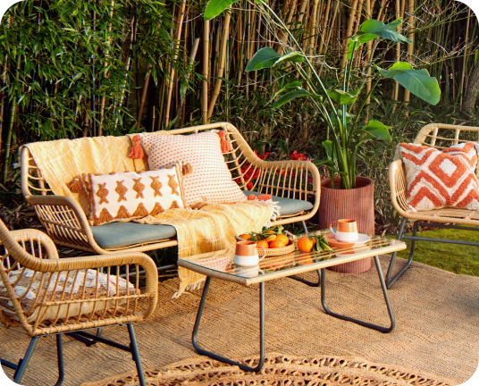 Rattan chairs around a coffee table in the garden linking to the garden sanctuary edit page