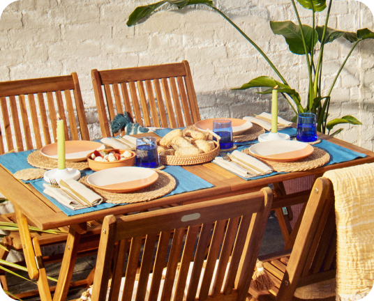 An outdoor dining table with place settings linking to european summer edit page