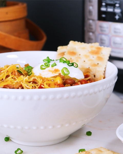 photo of a crockpot with a bowl of food next to it