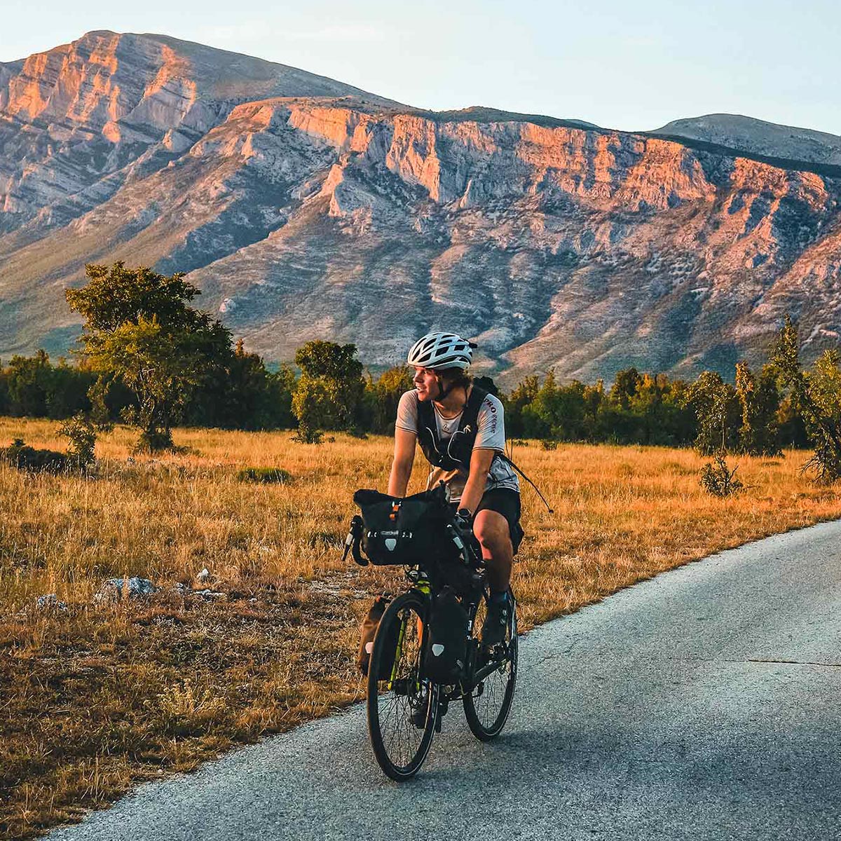 Tobias Renggli fährt Velo, im Hintergrund Berge   
