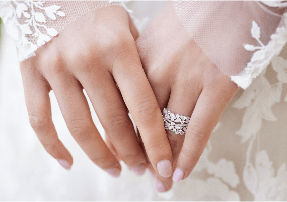 Close up of a woman in her beautiful dress displaying her wedding band.