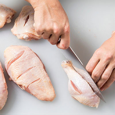 Slashing the raw pieces of chicken