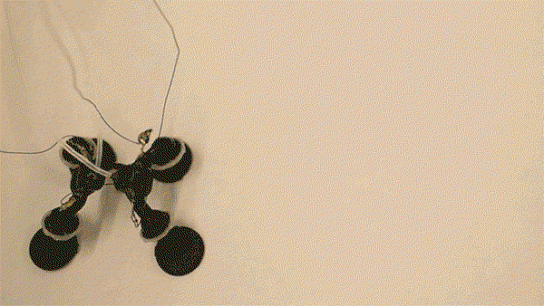 Animation of a small, four-legged robot made from plastic pieces that is hopping around in an uncontrolled fashion.