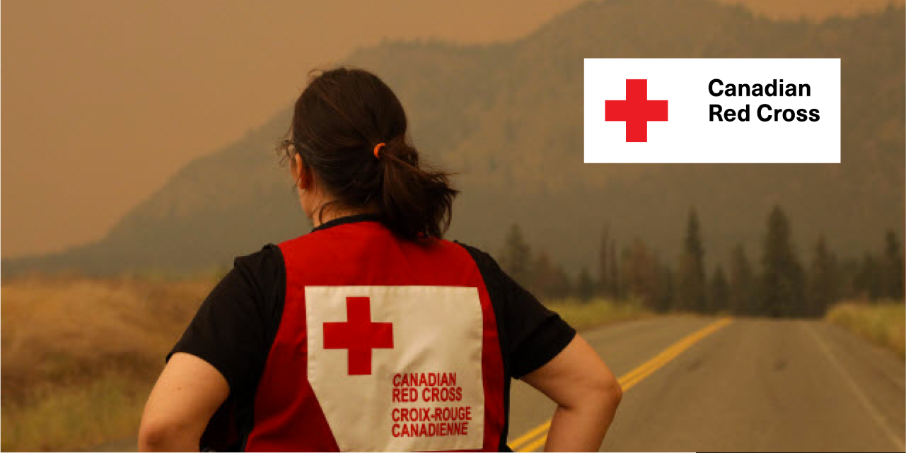 Photo of Canadian Red Cross representative looking away into forest fire smoke.