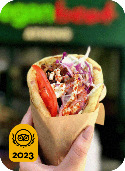 Image description: Close-up of a hand holding a gyro. Travelers’ Choice Best of the Best 2023 yellow logo in the bottom left corner.