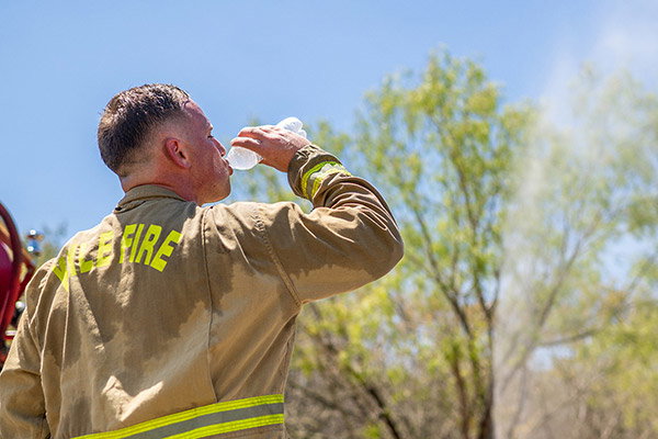 A firefighter takes a water break while combating a wildfire during an excessive heat warning in Texas.