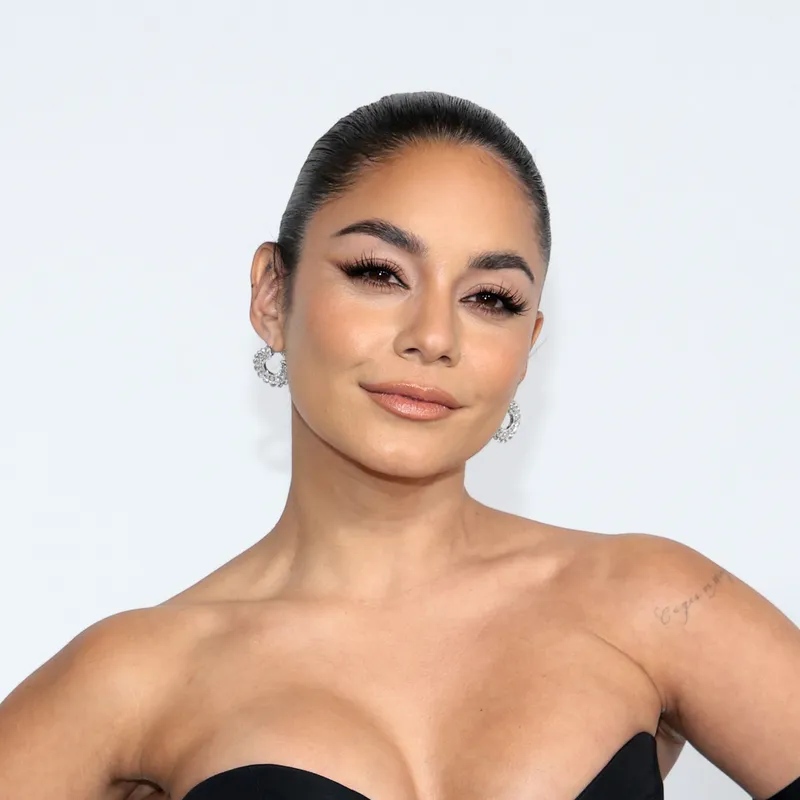 Vanessa Hudgens appears at an event in a strapless black gown and gloves.