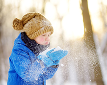 Image of a child playing outside in the snow.