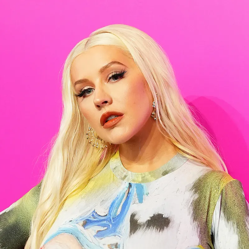 Christina Aguilera appears at an event in an illusion dress and long blonde waves.