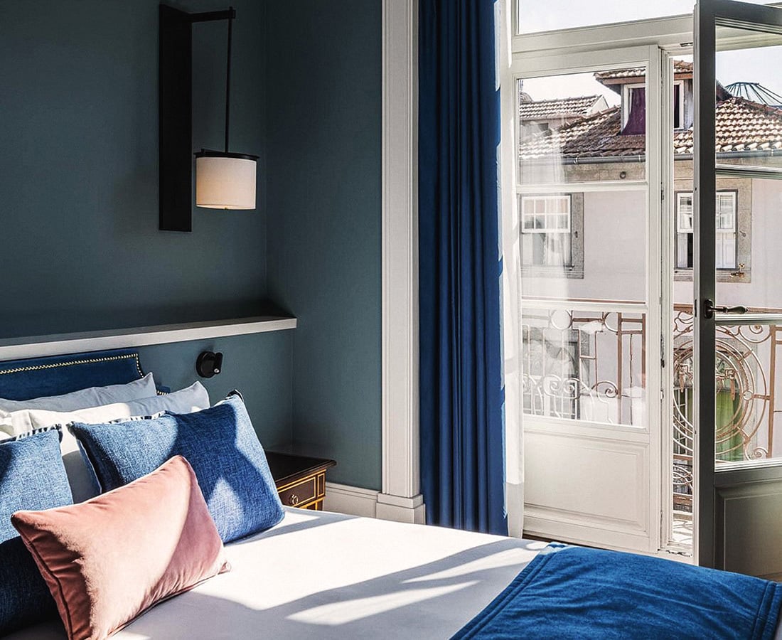 Image description: A blue hotel room with views of a charming city.