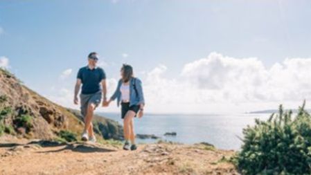 A couple walk hand in hand by the sea