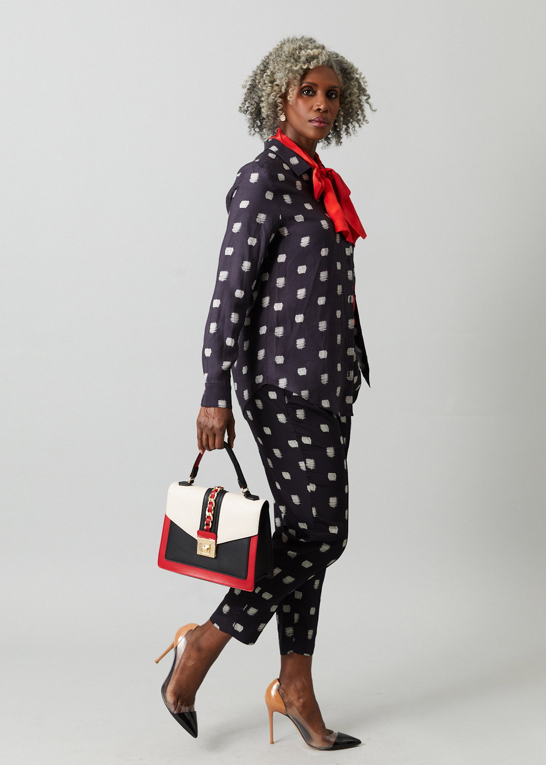 woman wearing tucker carrying a bag