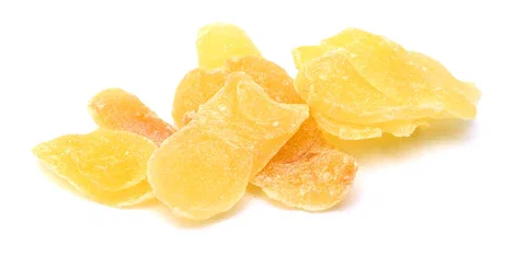 Some yellow candied ginger on a white background