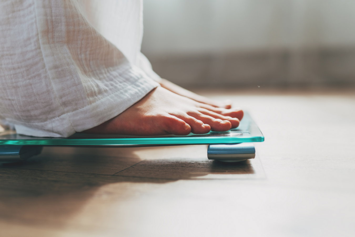 A close-up of someone's feet as they stand on weighing scales