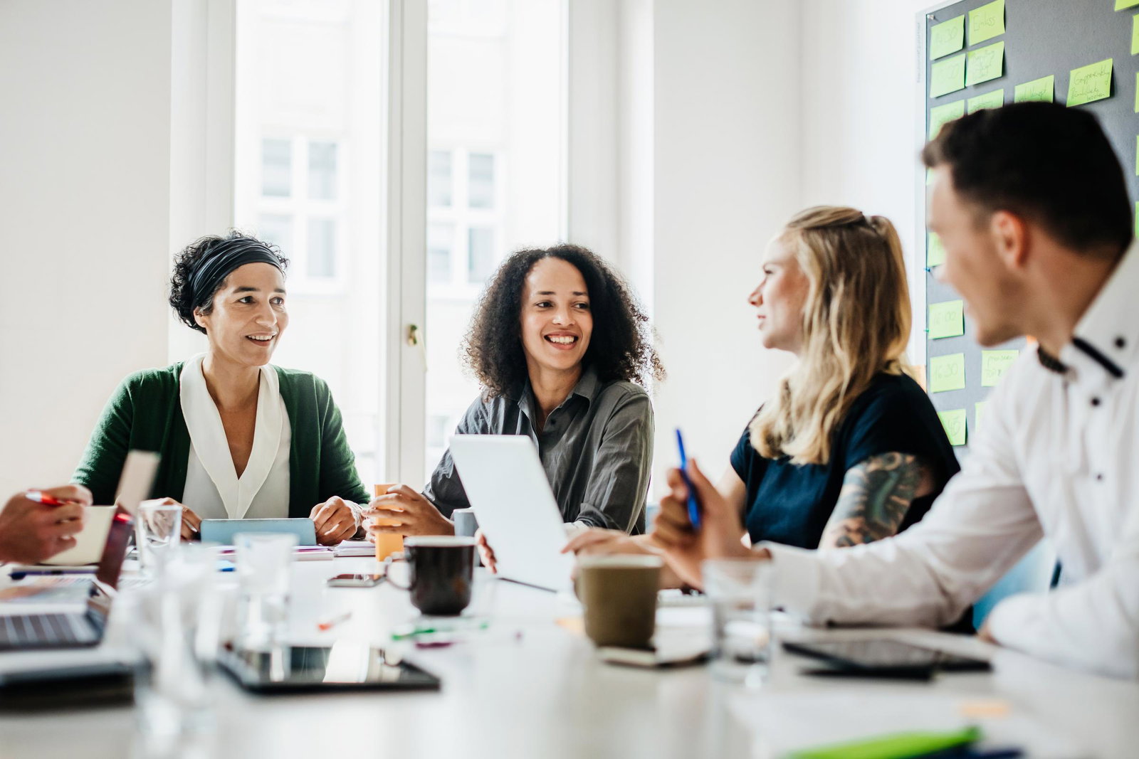 Four people smiling in a business meeting