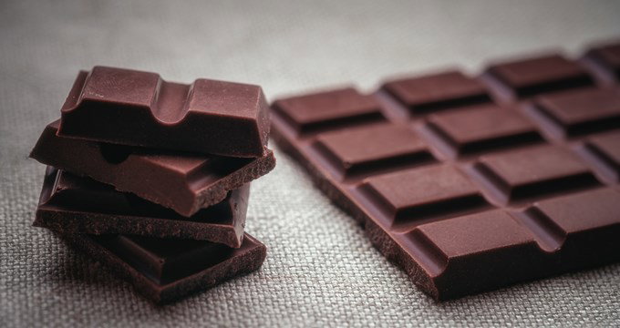Chocolate bar pieces on grey background