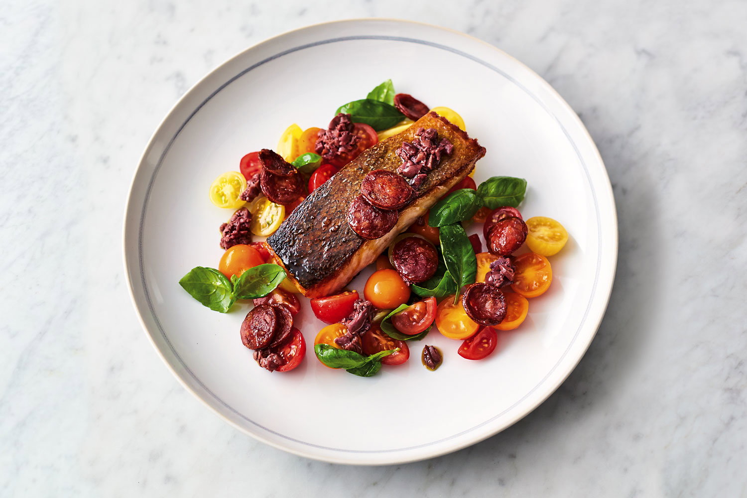 Smoky chorizo salmon, tomatoes and basil on a plate