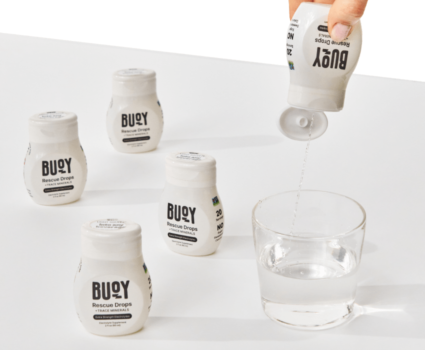 5 bottles of Rescue Drops and one of them is being squeezed into a glass of water.