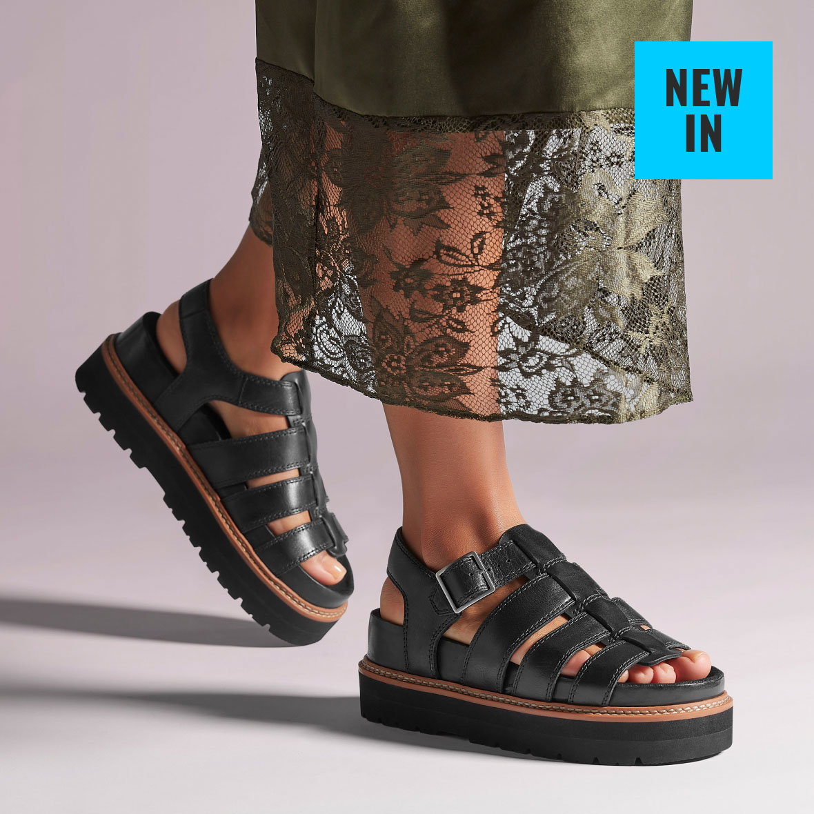 Shoes on feet image of sandals Orianna Twist in black leather links to product page