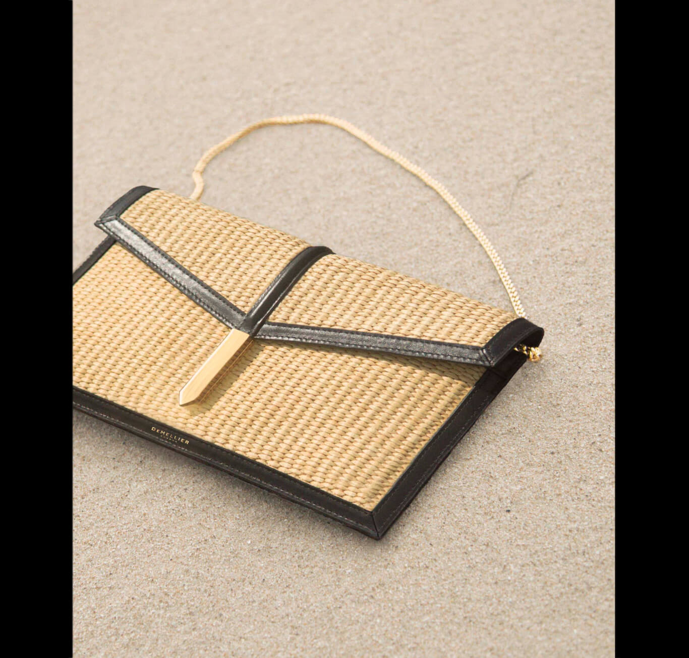 the tokyo clutch in warm raffia and black smooth