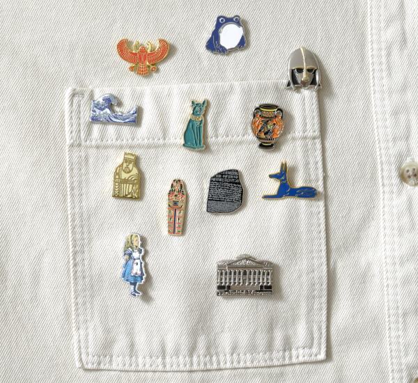 A selection of pin badges on a white denim pocket