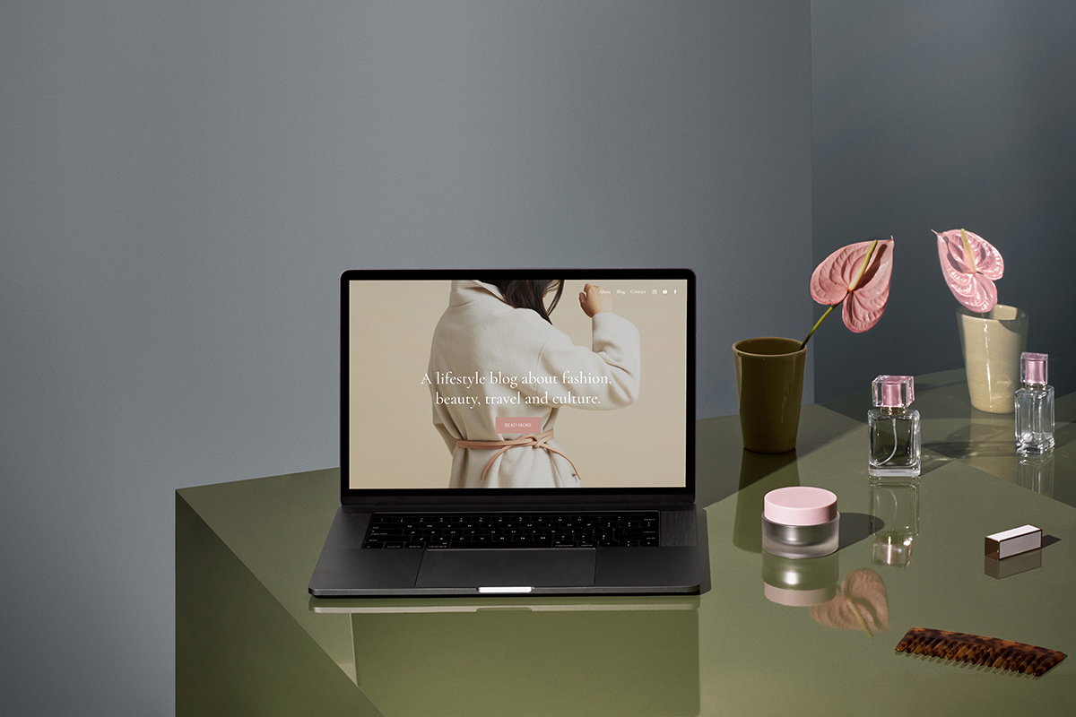 table with beauty products and laptop showing screen of lifestyle blog
