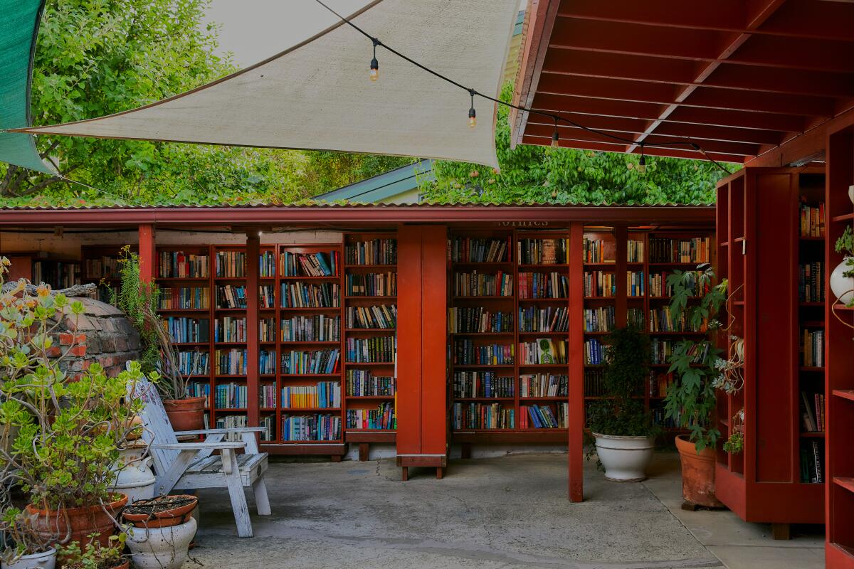A photo of walls of books surrounding a courtyard filled with reading nooks and plants