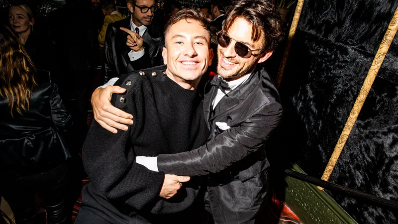 Image may contain: Jonathan Bailey, Clothing, Coat, Jacket, Adult, Person, Accessories, Glasses, and Photobombing