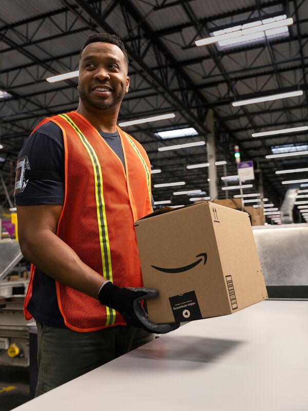 An Amazon associate holding an Amazon package