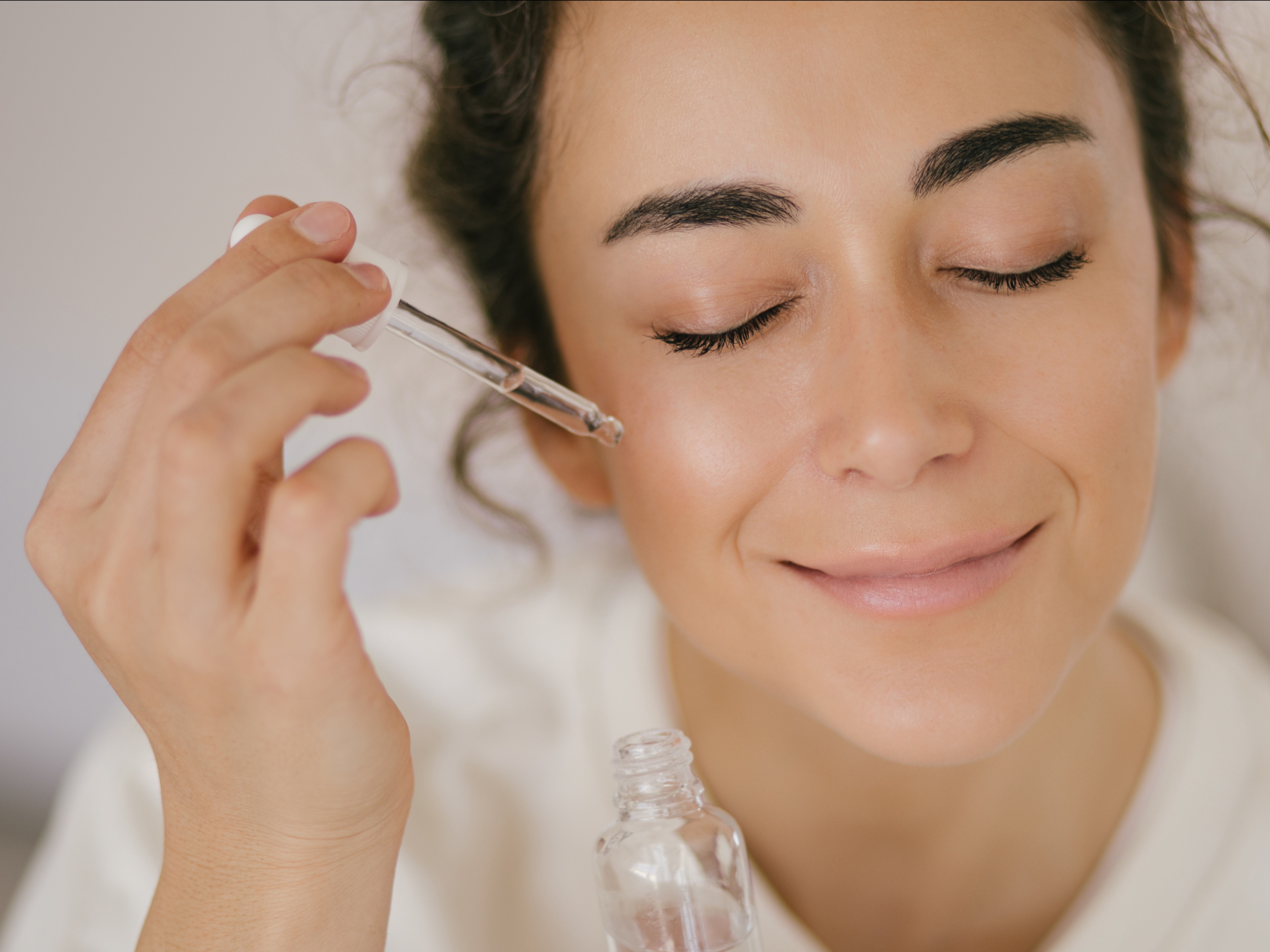 Woman applying Hamdah London customised skincare product to her face