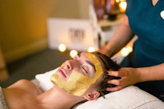 Woman lying down having a spa treatment with a gold leaf mask