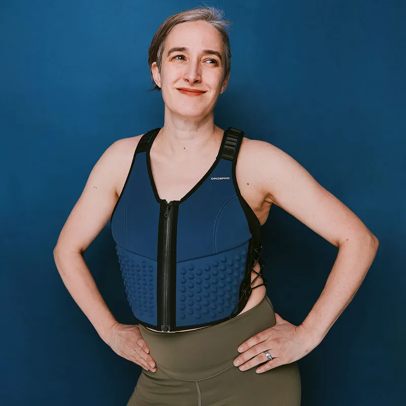 Figure wearing navy blue weighted vest against navy blue background