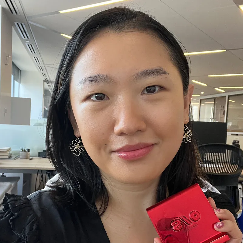 Side-by-side selfies of two people holding a makeup compact for powder foundation while softly smiling