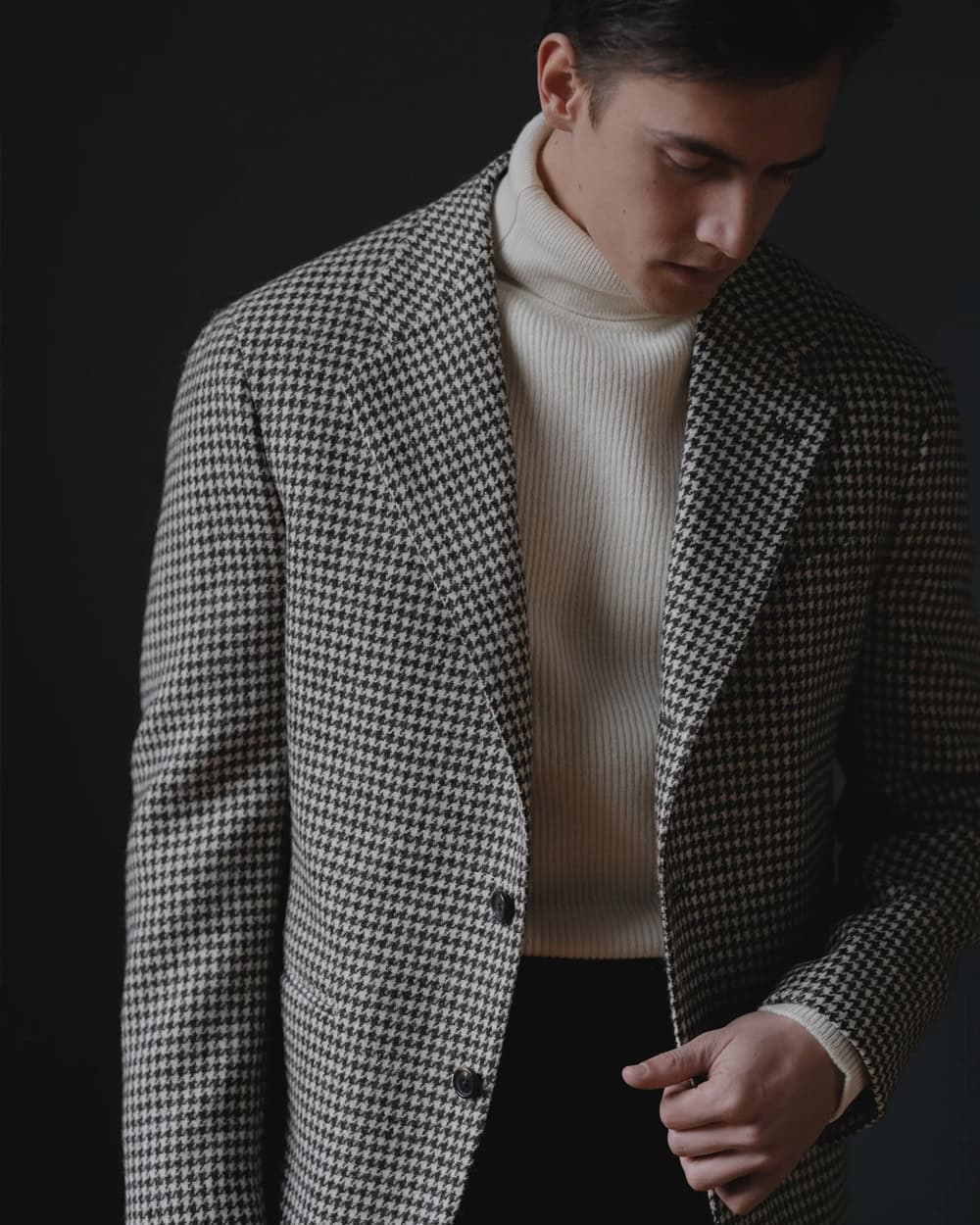 a man wearing a suit and tie and a sweater