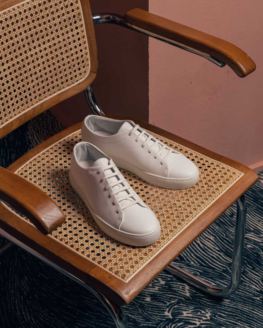 a pair of white shoes sitting on a chair
