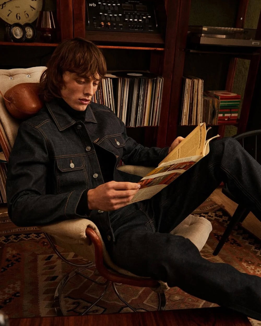 a man sitting in a chair reading a book
