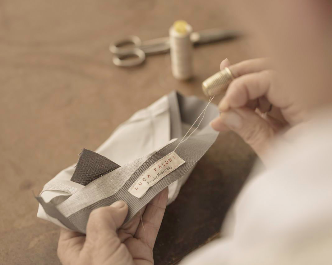 A man sewing a label into a shirt
