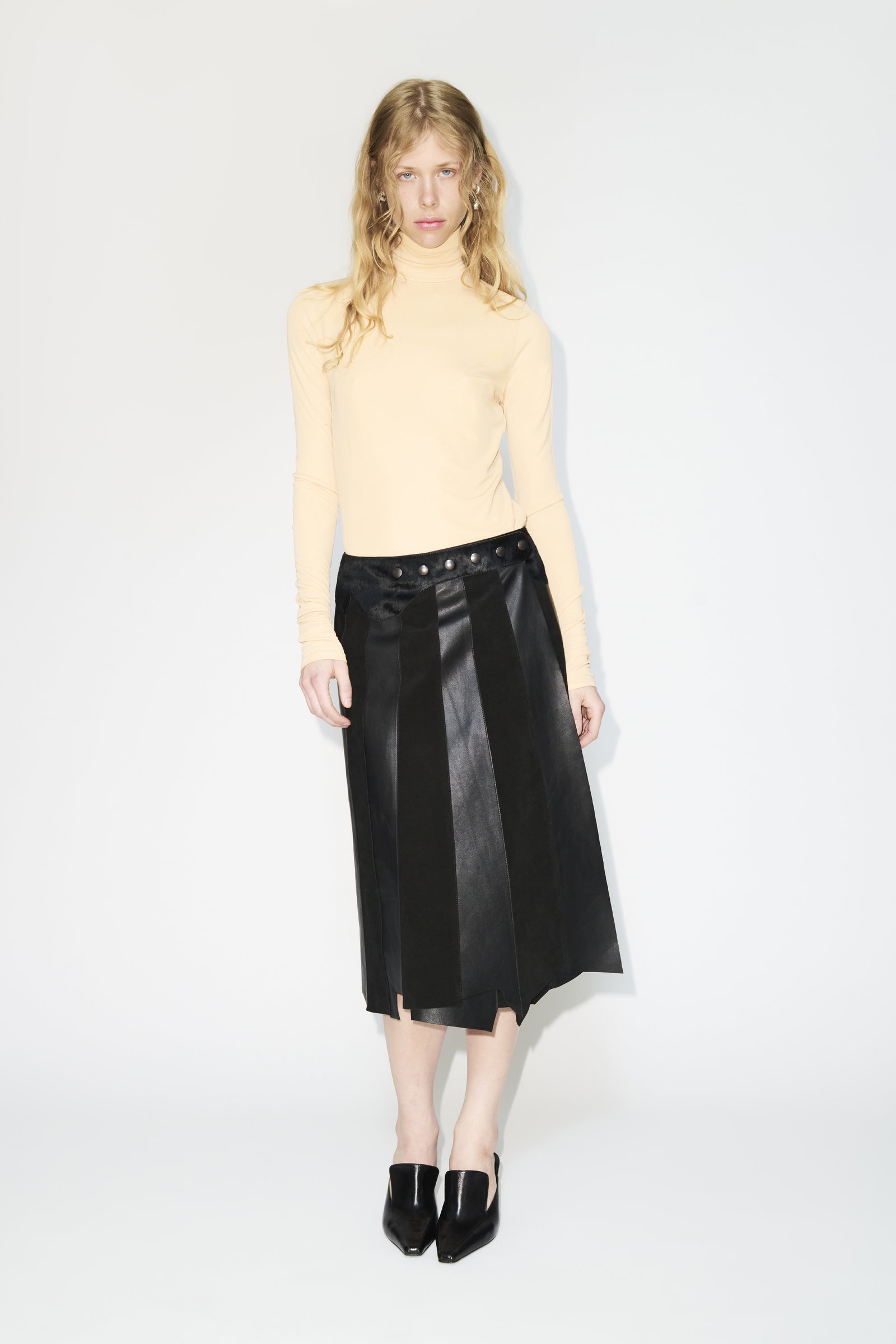 a woman wearing a white shirt and a tan skirt