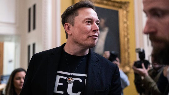 Elon Musk with photographers in the background