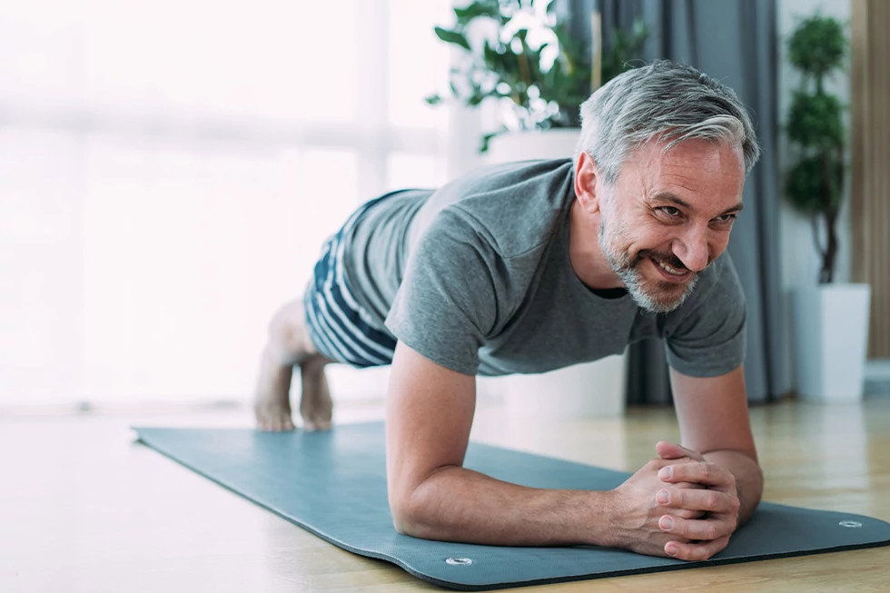 Man planking on workout mat in living room