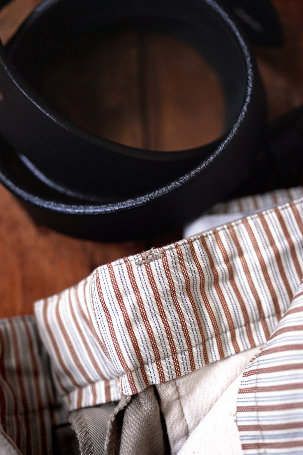 A closeup of Bills Khakis Vintage twill shorts and a belt