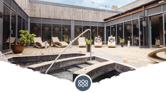 two women relaxing on loungers by the pool at the well spa