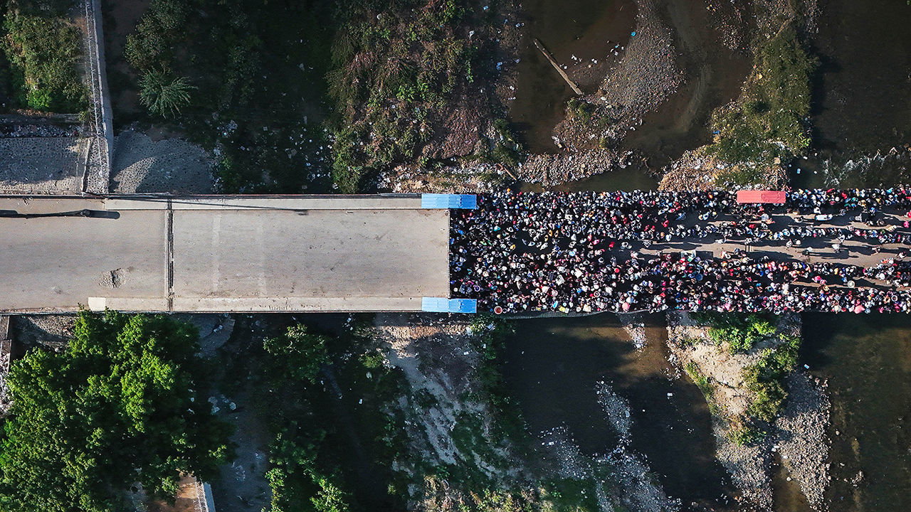 People wait in Ouanaminthe, Haiti to cross into Dajabon, Dominican Republic