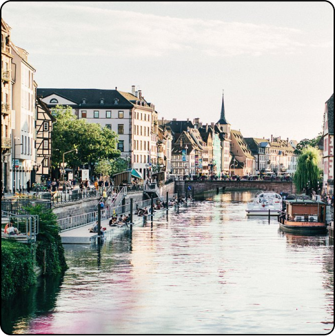 Image Description: Waterway with old buildings lining the sides and small pedestrian bridge in the distance.