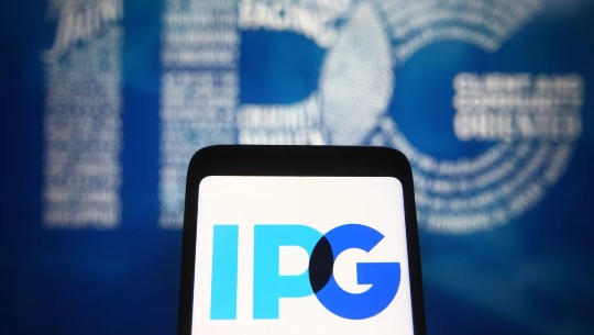 The IPG logo on a smartphone screen and on a wall